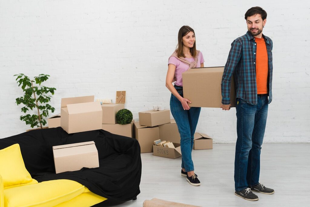 Pareja cargando cajas de cartón durante una mudanza